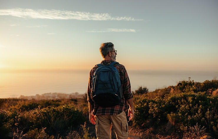 older man on hillside at sunset, hiking