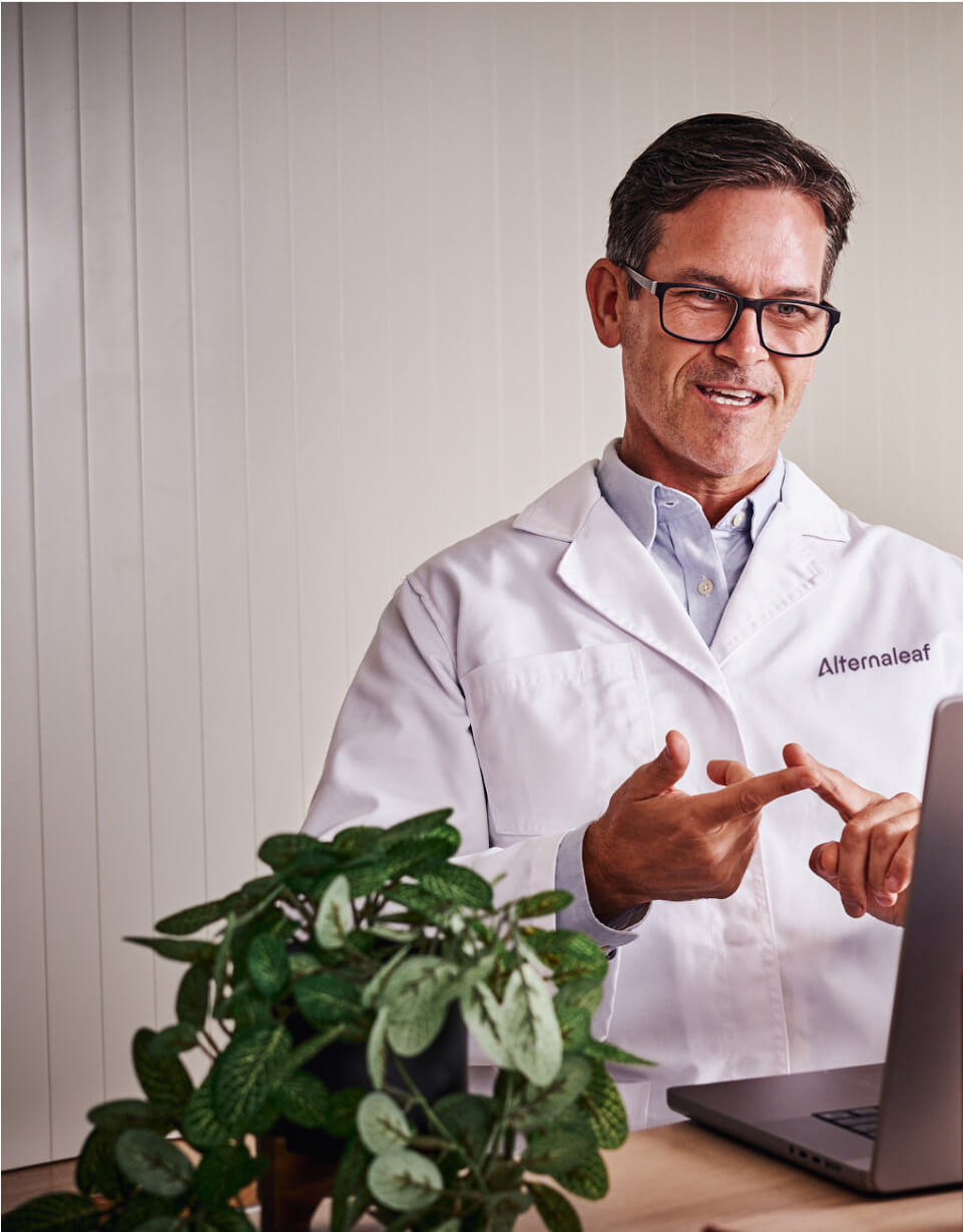 a male in a white lab coat is using a laptop