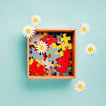 box of puzzle pieces, and paper flowers